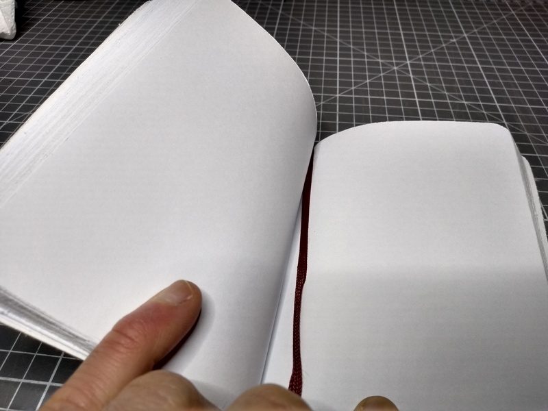 An open notebook with blank pages. The sides of the paper are visibly rough.