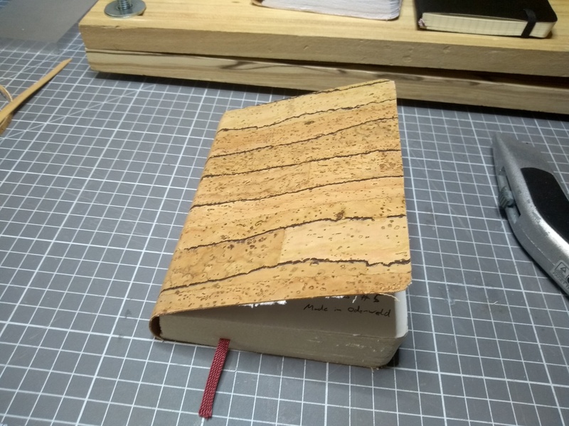 A closed notebook, bound in cork leather.