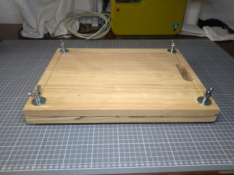 A book press, built from two cutting boards and some bolts and wing nuts from the hardware store.