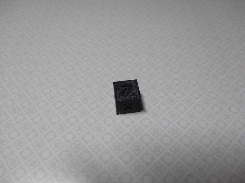 A flawless calibration cube, 3D-printed in black PLA.